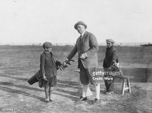 Mr Clifford B Harman on the golf course with his caddies.