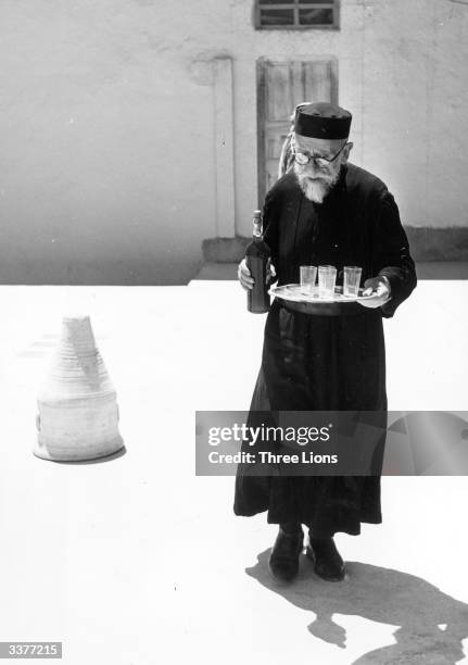 Peter Gregoire, of the Greek Catholic monastery of Mar Sarkis in the Syrian village of Maaloula, with a bottle of the monastery's wine.