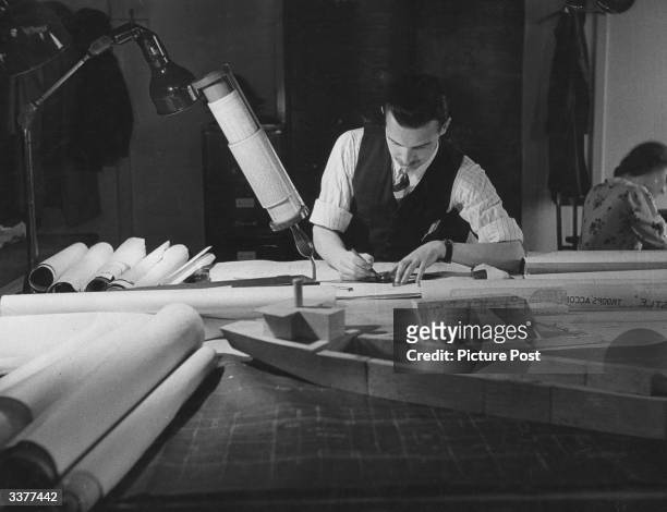 Goodfellow, a technical assistant, drawing up plans to convert a liner into a troop ship. Original Publication: Picture Post - 1245 - Transport - The...