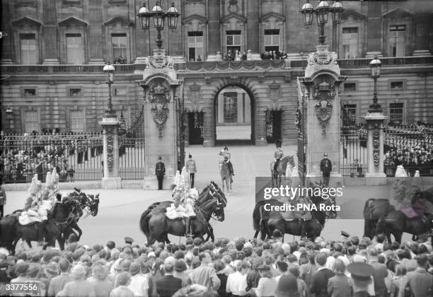Queen Elizabeth II, mounted on a horse at the gate of Buckingham Palace, London, taking the salute at the annual Trooping of the Colour ceremony.