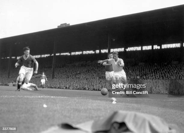 Manchester City inside left Jack Dyson is chased by Manchester United right back Bill Foulkes and centre half Mark Jones, during a keenly fought...