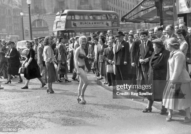 Year old usherette Margaret Lewis from Carmaethen, Wales, who lives in Kensington, caused a stir in Piccadilly when she decided to beat the heat wave...