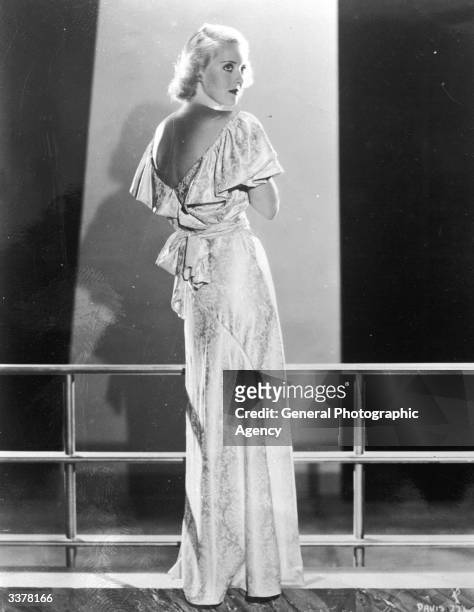 Actress Bette Davis wearing an evening dress.