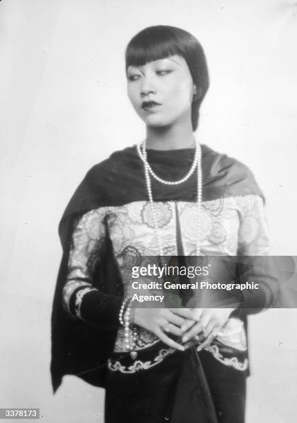 American-Chinese actress Anna May Wong wearing a long string of beads.