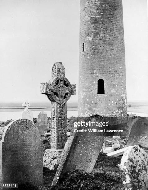 Celtic cross and round tower at Clonmacnoise, County Offaly, a centre of early Irish Christianity founded by St Ciaran circa 545.