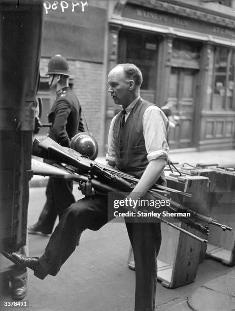 Policemen collecting firearms from licensed firearms dealer in London. Altogether ?15,000 of arms were tken from this one dealer.