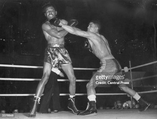 British boxer Randolph Turpin lands a straight left to Sugar Ray Robinson's chin on his way to beating the American for the world middleweight title...