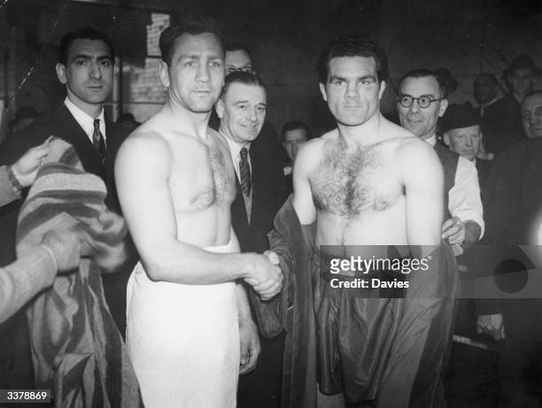 Russian-American boxer Gus Lesnevich shakes hands with Britain's Freddie Mills at the weigh-in for their world light-heavyweight title fight in...