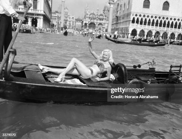 British actress, Diana Dors wearing a mink bikini whilst riding in a Gondola by St. Mark's Square, Venice during the Venice film festival, 5th May...
