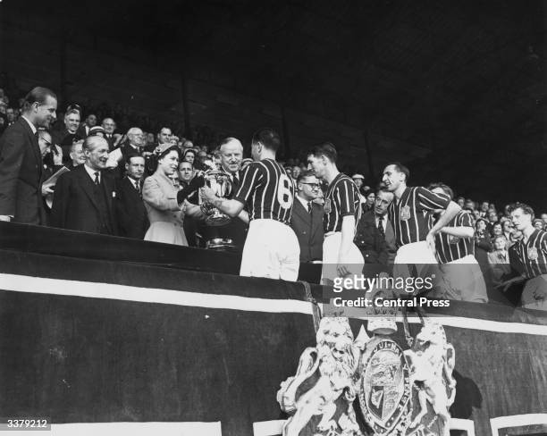Queen Elizabeth II presents the FA Cup trophy to R Paul of Manchester City after his side's 3-1 victory over Birmingham City in the FA Cup final at...