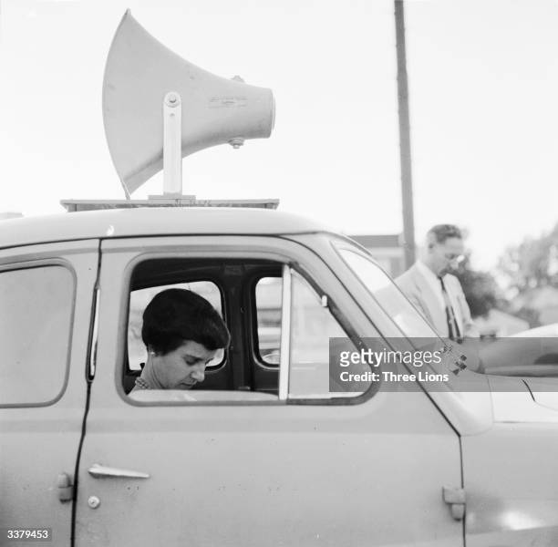 Car with a loadspeaker attached to its roof broadcasting a preaching evangelical minister's sermon during a mass held in a car park in Scarborough,...