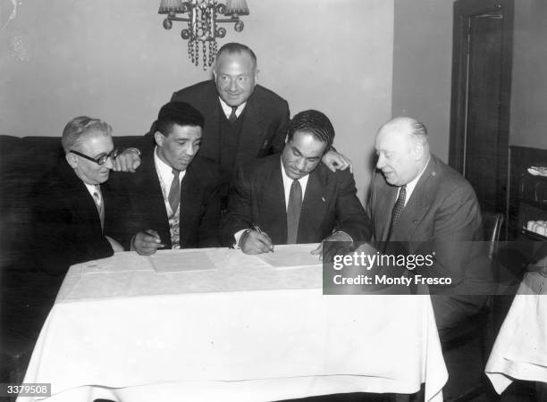 British light-heavyweight boxing champion Alex Buxton and Randolph Turpin signing for their forthcoming British and Empire title fight.