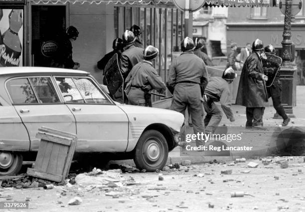 Riot police shield themselves as students throw missiles during the Paris uprising in May 1968.