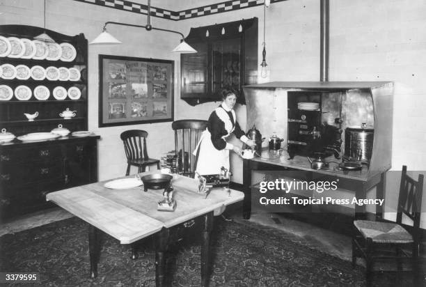 An electric iron, kettle, curling tongs and shaving pot on display at The Electrical Exhibition, Manchester.