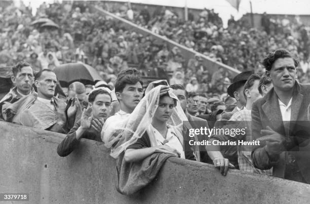 Crowds watching the 1948 London Olympics in the rain at Wembley Stadium. Original Publication: Picture Post - 4582 - Olympic Games - pub. 1948