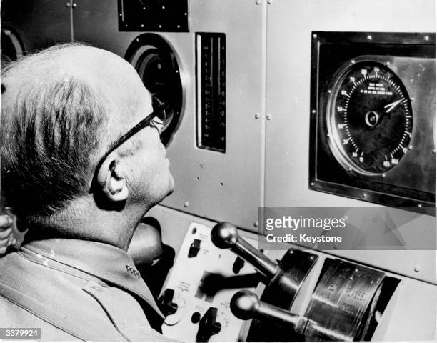 Admiral Robert B Carney observing the depth gauges of the world's first nuclear powered submarine 'Nautilus'.