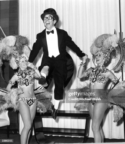 British comedian, Ronnie Corbett dancing with two cabaret dancers during a rehearsal for his two week season at the Savoy Hotel, London.