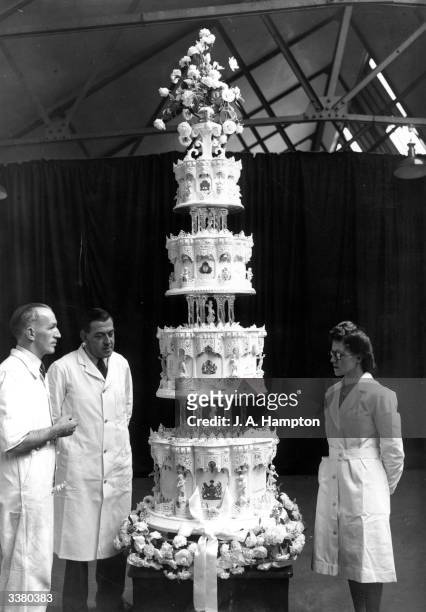 Mr Schur , chief confectioner at McVitie and Price Ltd, standing next to the official cake for Princess Elizabeth's marriage to Philip Mountbatten...