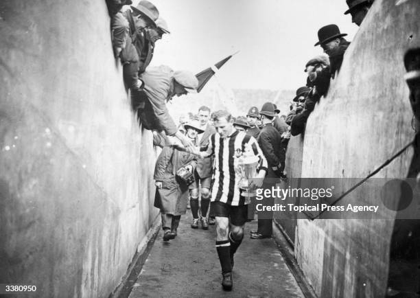 Newcastle United FC full back Frank Hudspeth carries the FA Cup trophy back down the players tunnel after the presentation and celebrations of...