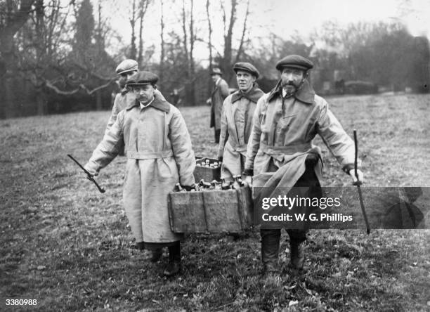 Beaters carrying refreshments for huntsmen on a pheasant shoot at Hackwood Park, Basingstoke.