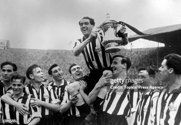 Newcastle United Football Club captain Joe Harvey is held aloft with the FA Cup trophy after their 2-0 victory over Blackpool in the FA Cup final at...