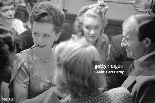 Frank Launder, film director and president of the Screenwriters' Association, with his wife and Susan Shaw at the Screenwriters' Club in London....