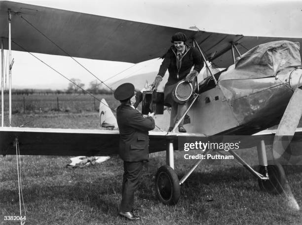 Aviator Winifred Brown is offered a helping hand as she climbs down from her bi-plane on arrival at Gleneagles for an air rally.