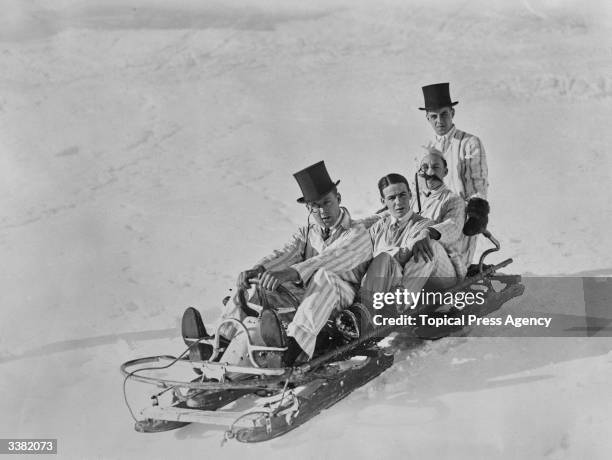Jimmy Botterell of London and companions, dressed in striped suits and top hats, on a bobsleigh at St Moritz.