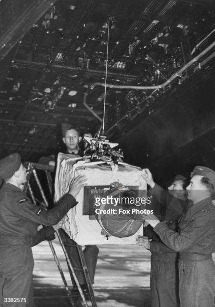 Personnel loading a bomb, containing roses, carnations, lilacs and a message to Queen Wilhelmina of the Netherlands from Chief of Air Staff Lord...