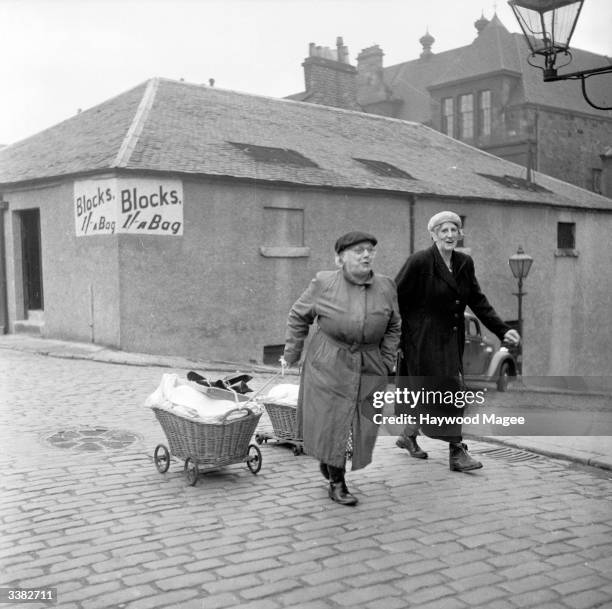 Two housewives on their way home from a Corporation wash-house with their barrows of laundry. Many Glaswegian housewives do their laundry at a...