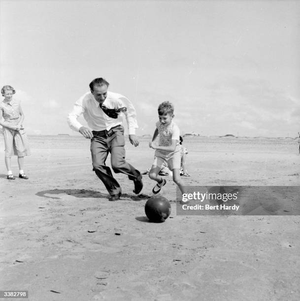 The country's most famous football player, Stanley Matthews of Blackpool FC, plays with his son Stanley Junior on the beach. Original Publication:...