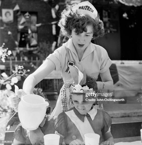 Mother organises more refreshments for a street party at Morpeth Street, in London's East End, to celebrate the Coronation of Queen Elizabeth II....