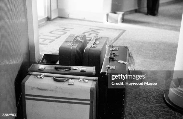 Pile of suitcases deposited in the doorway of the Merton Hotel on Jersey. Original Publication: Picture Post - 6496 - Honeymoon In Jersey - pub. 1953