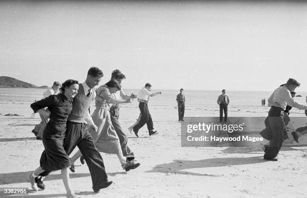 Group of newly-wed couples take part in a three-legged race during their honeymoon at the Merton Hotel on Jersey. Original Publication: Picture Post...