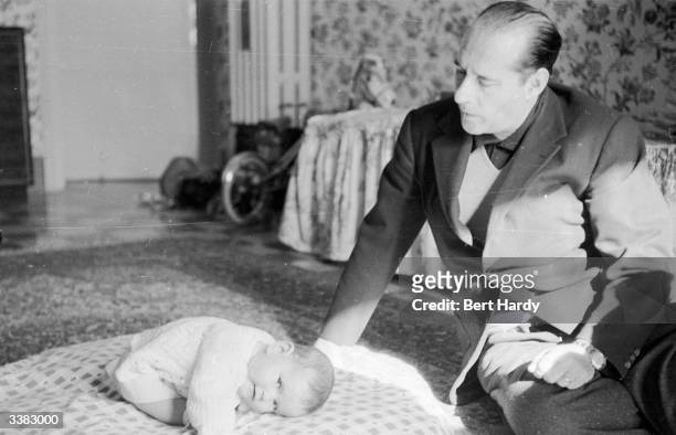 Italian film director Roberto Rossellini with his eleven-month-old daughter Isabella. Original Publication: Picture Post - 6514 - Ingrid Bergman's...