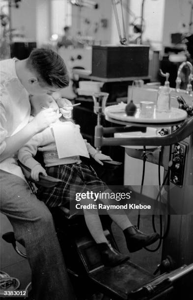 Child having their teeth examined by a dentist. Original Publication: Picture Post - 6424 - The Truth About Your Teeth - pub. 1953