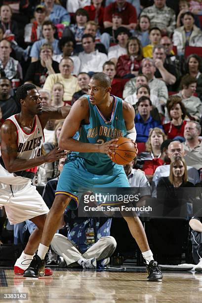 Jamaal Magloire of the New Orleans Hornets looks to play the ball against Dale Davis of the Portland Trail Blazers during the game at the Rose Garden...