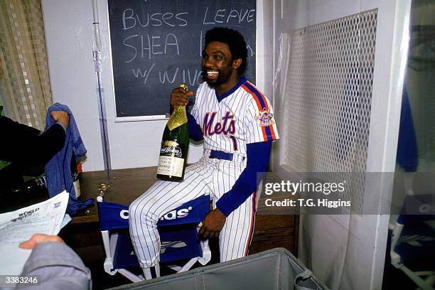 Outfielder Mookie Wilson of the New York Mets celebrates with a bottle of champagne after winning game 7 of the 1986 World Series against the Boston...