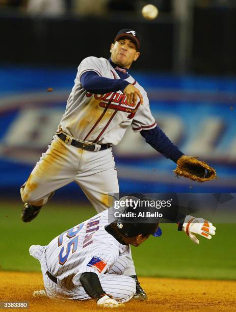 Marcus Giles of the Atlanta Braves turns a double play as Kazuo Matsui of the New York Mets slides into second base during their game on April 15,...