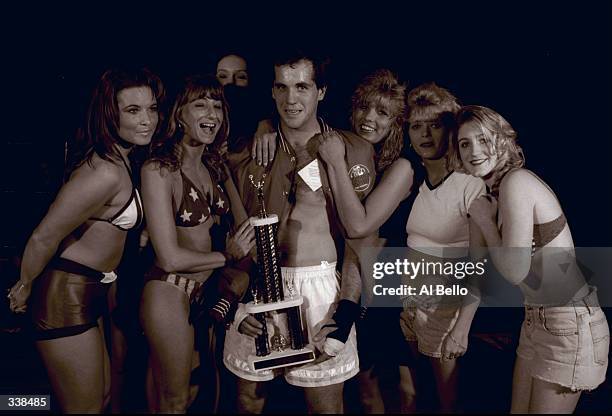 Unidentified winner holds a trophy and enjoys attention following the Toughman Contest in Kalamazoo, Michigan. Mandatory Credit: Al Bello /Allsport