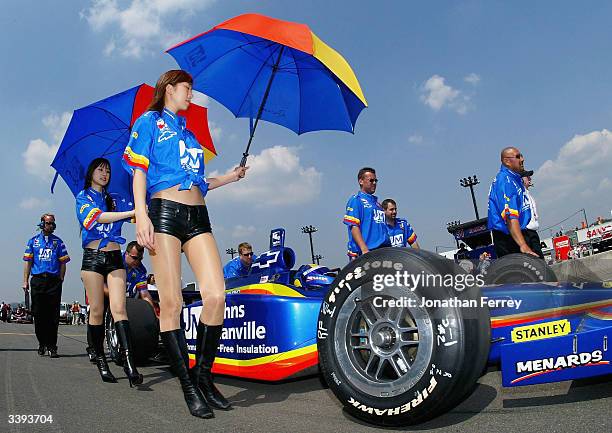 Grid girls shade Mark Taylor with their umbrellas as he sits in his Panther Chevrolet Dallara during qualifying for the IRL IndyCar Series...