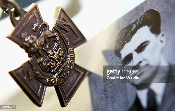 Rare Victoria Cross medal is displayed next to a portrait of Warrant Officer Norman Cyril Jackson at Spink auction house April 16, 2004 in London....