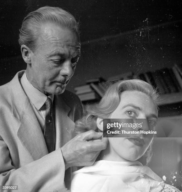 Piercer, Cyril Wilkinson, piercing a young lady's ear. Original Publication: Picture Post - 6607 - Ladies, Who's For Piercing? - pub. 1953