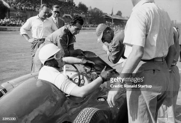 Racing driver and a group of mechanics in the pitstop at the Monza Grand Prix in Italy. Original Publication: Picture Post - 6740 - Ferrari's Last...