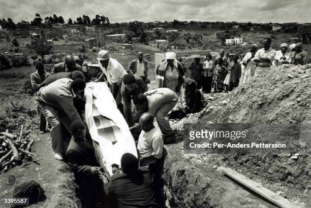 Men lower a coffin with a woman who died of a AIDS related disease on September 13, 1999 in Gamalakhe, in Natal, South Africa. South Coast Hospice, a...