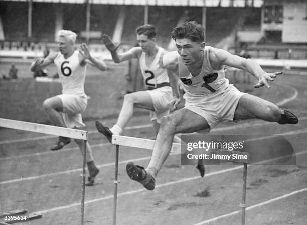 An Amateur Athletics Association hurdle race at White City in London. Left to right: P Freeman, E Abbott and J R Birrell, who is England's choice for...