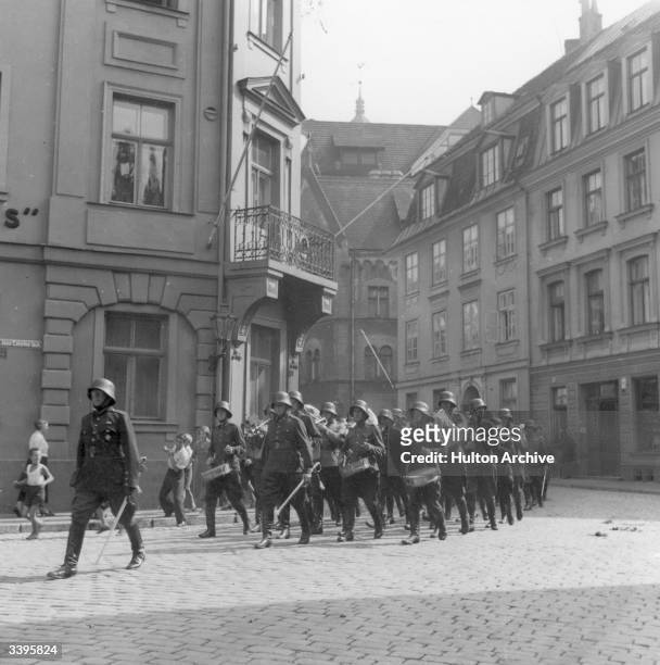 Steel helmetted soldiers playing drums as they march through a street in Riga capital of Latvia, during WW II.