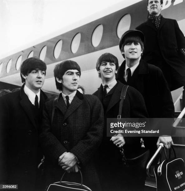 British pop phenomenon The Beatles standing on the steps of an aeroplane at London Airport. Left to right, Paul McCartney, George Harrison , Ringo...