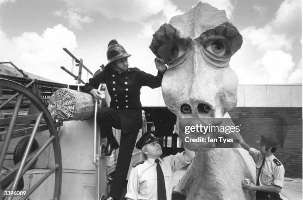 Firemen from Hemel Hempstead, London, adding the finishing touches to a seductive female Nessie, intended to lure the Loch Ness Monster from his...