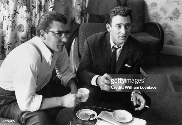 London gangsters Ronnie and Reggie Kray having a cup of tea at home. They had just spent 36 hours being questioned by the police about the murder of...